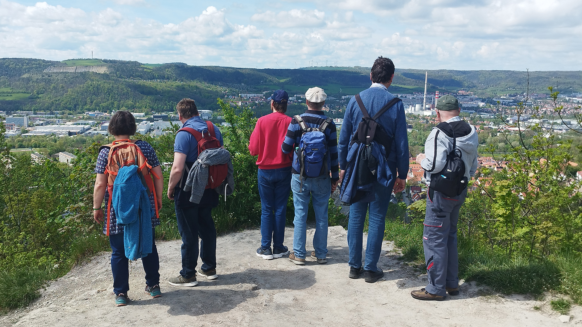 Sechs Personen stehen auf einem Berg und schauen in das Tal auf Jena.